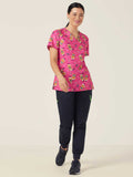 Workin Gear Woman wearing a pink Christmas scrub top  
